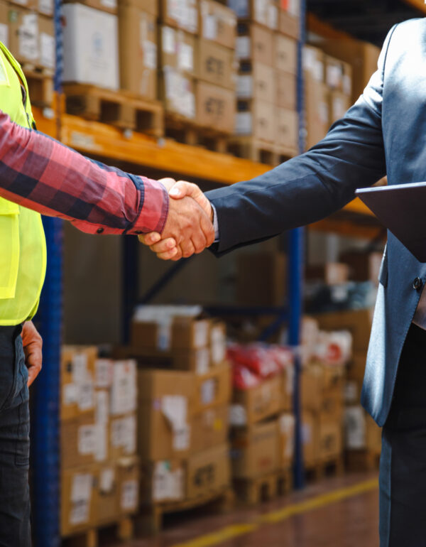 2 men shaking hands in warehouse